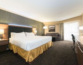 King guest room with natural light, work desk, and comfortable seating at Holiday Inn Express Edmonton Downtown, an IHG Hotel.