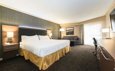 King guest room with natural light, work desk, and comfortable seating at Holiday Inn Express Edmonton Downtown, an IHG Hotel.