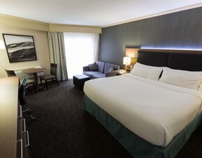 Spacious king guest room featuring a sofa, work desk, and modern amenities at Holiday Inn Express Edmonton Downtown, an IHG Hotel.