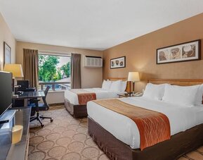 Guest room with two queen beds and a work desk at Comfort Inn Brantford.