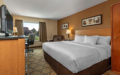 King guest room with natural light and seating area at Comfort Inn Sept-Iles.