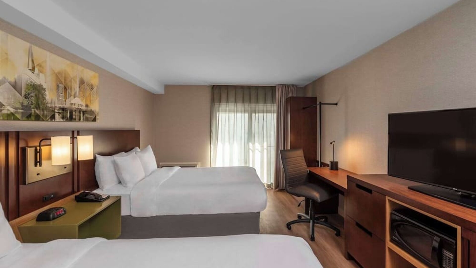 Guest room with two queen beds and a work desk at Comfort Inn Sault Ste. Marie.