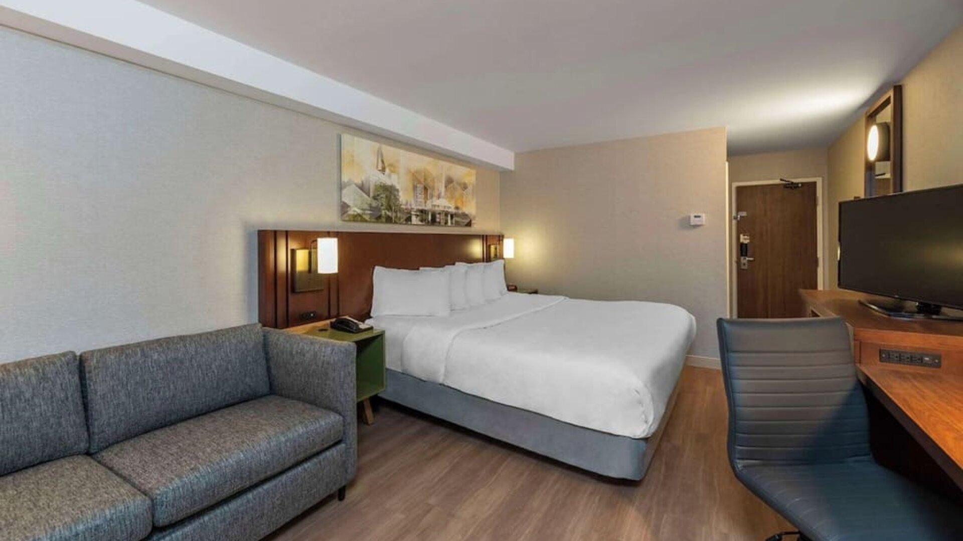 Spacious king guest room with a sofa and work desk at Comfort Inn Sault Ste. Marie.