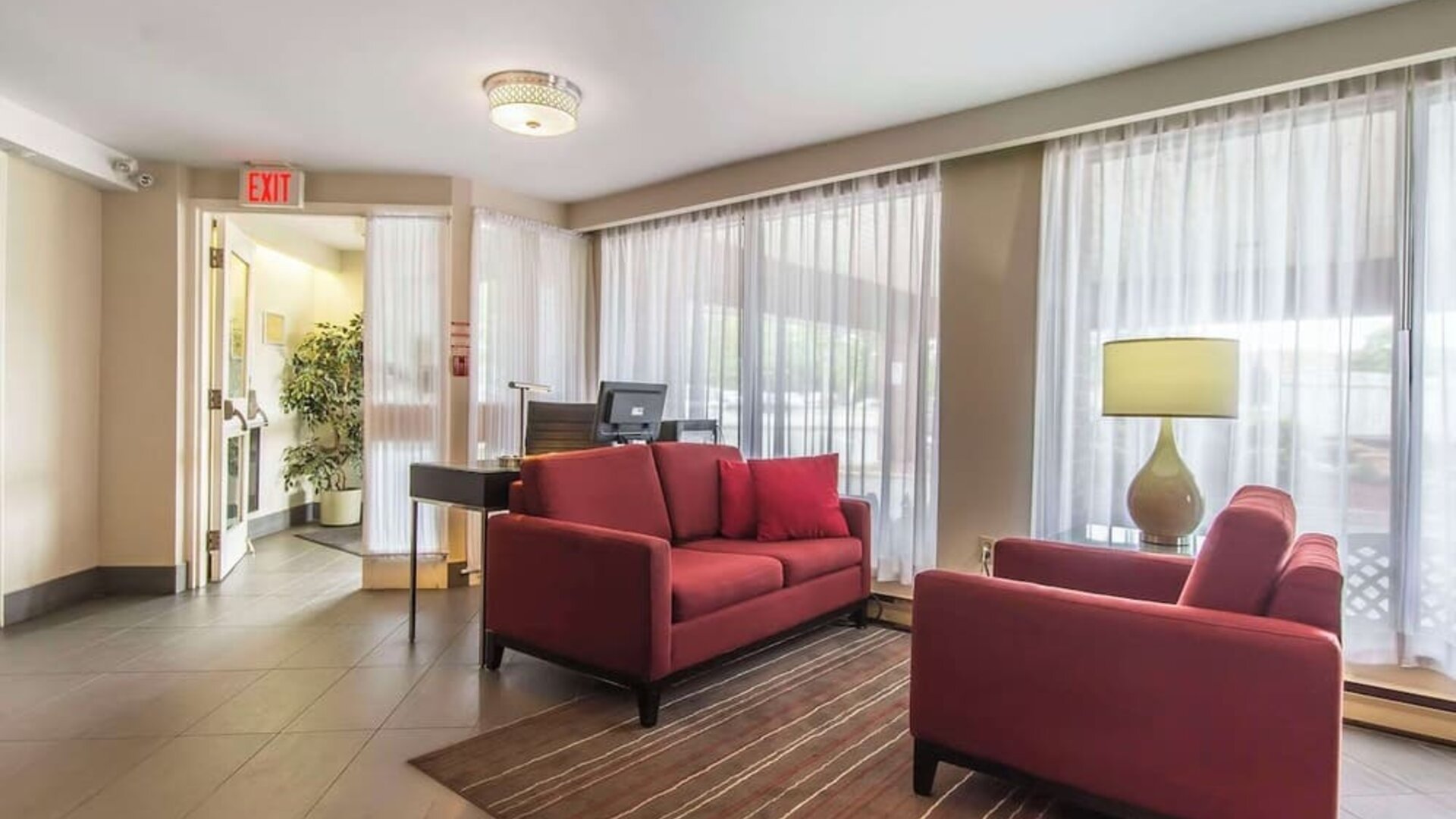Lobby seating area with large windows at Comfort Inn Sault Ste. Marie.