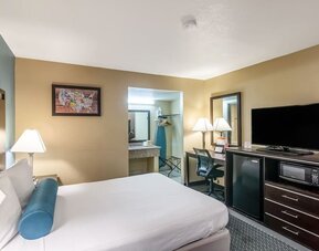Guest room with a king bed, work desk, TV, microwave, and mini fridge at Glenridge Inn Glendale Pasadena.
