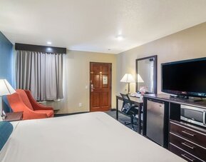 Guest room with a king bed, TV, work desk, and seating area at Glenridge Inn Glendale Pasadena.