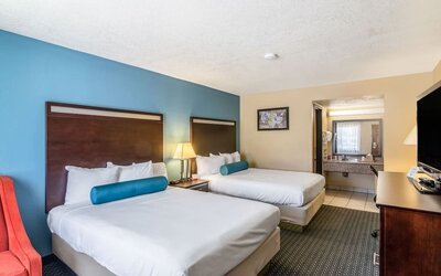 Guest room with two queen beds and a vanity area at Glenridge Inn Glendale Pasadena.