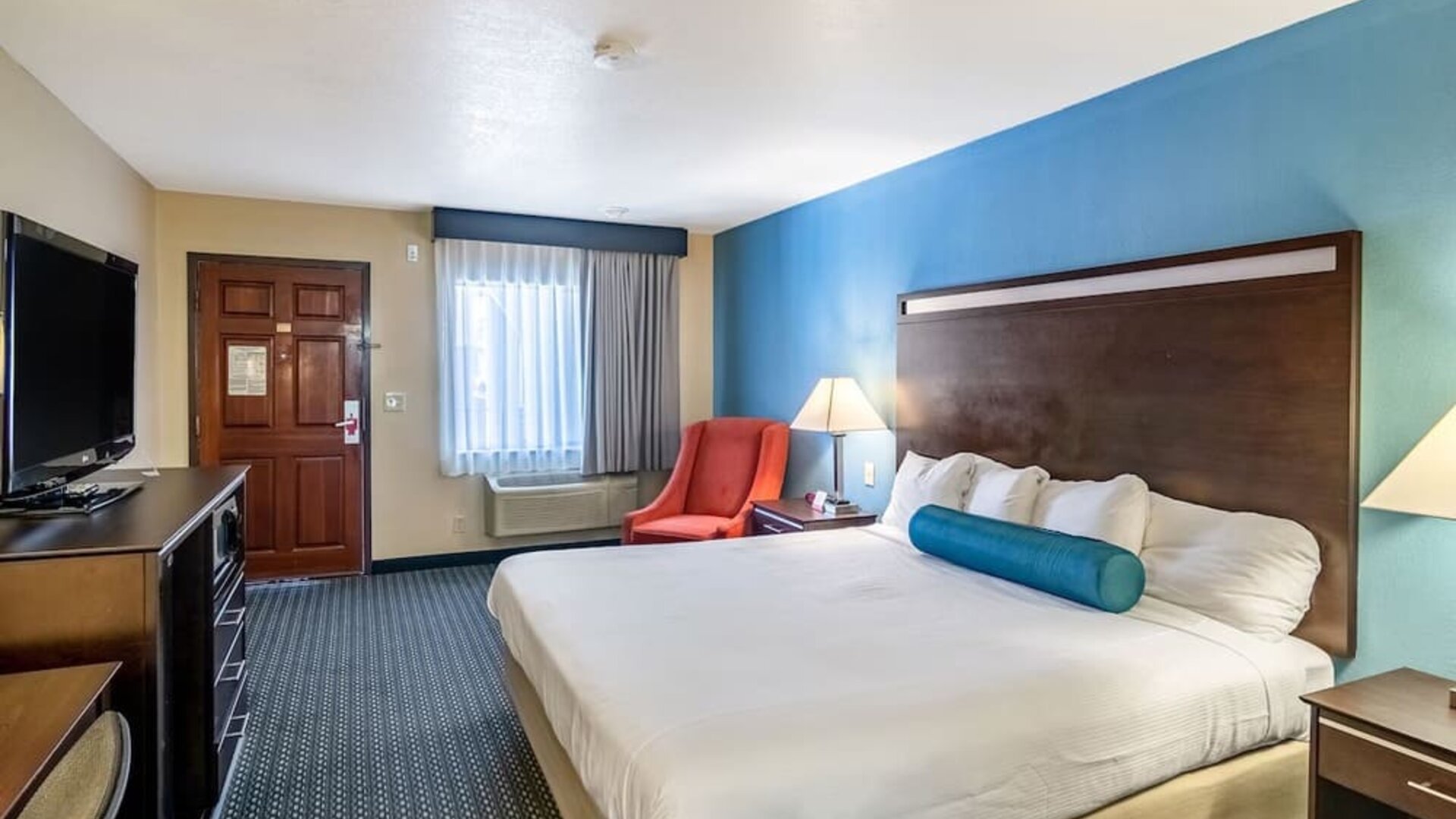 Spacious guest room with a king bed and seating area at Glenridge Inn Glendale Pasadena.