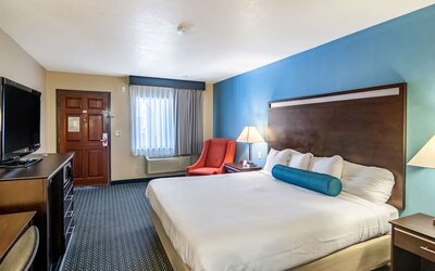 Spacious guest room with a king bed and seating area at Glenridge Inn Glendale Pasadena.