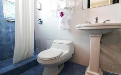 Guest bathroom with shower at Hollywood Beach Suites, A South Beach Group Hotel.