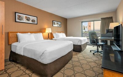 Guest room with two queen beds and a work desk at Comfort Inn Regina.