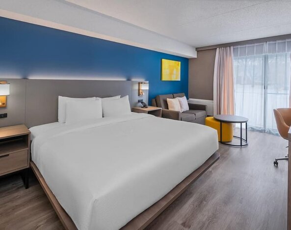 Guest room with a king bed, sofa, and workspace at Comfort Inn Belleville.