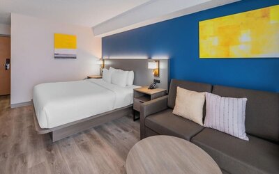 Guest room with a king bed, sofa, and seating area at Comfort Inn Belleville.