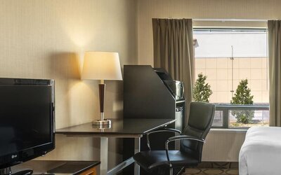 In-room workspace with a desk, TV, and mini fridge at Comfort Inn Swift Current.