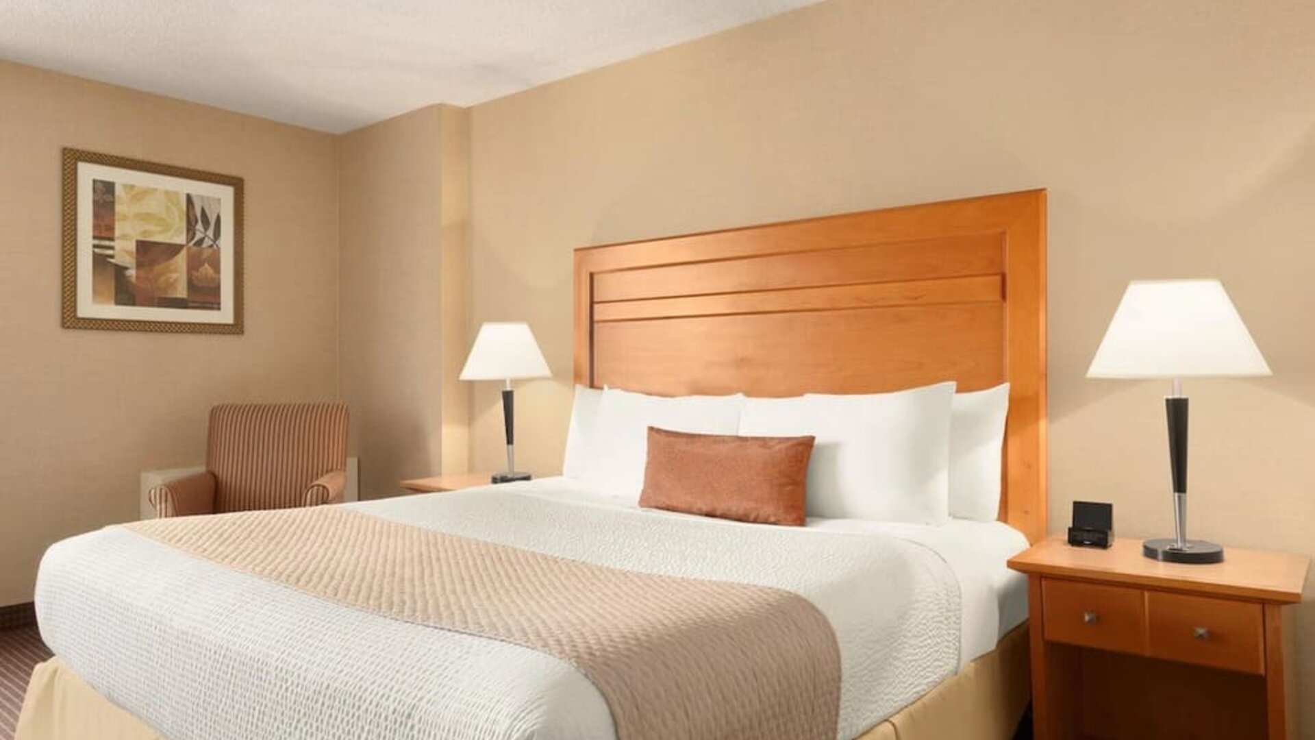 Guest room with a king bed and bedside lighting at Days Inn Edmonton Downtown.