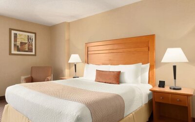 Guest room with a king bed and bedside lighting at Days Inn Edmonton Downtown.