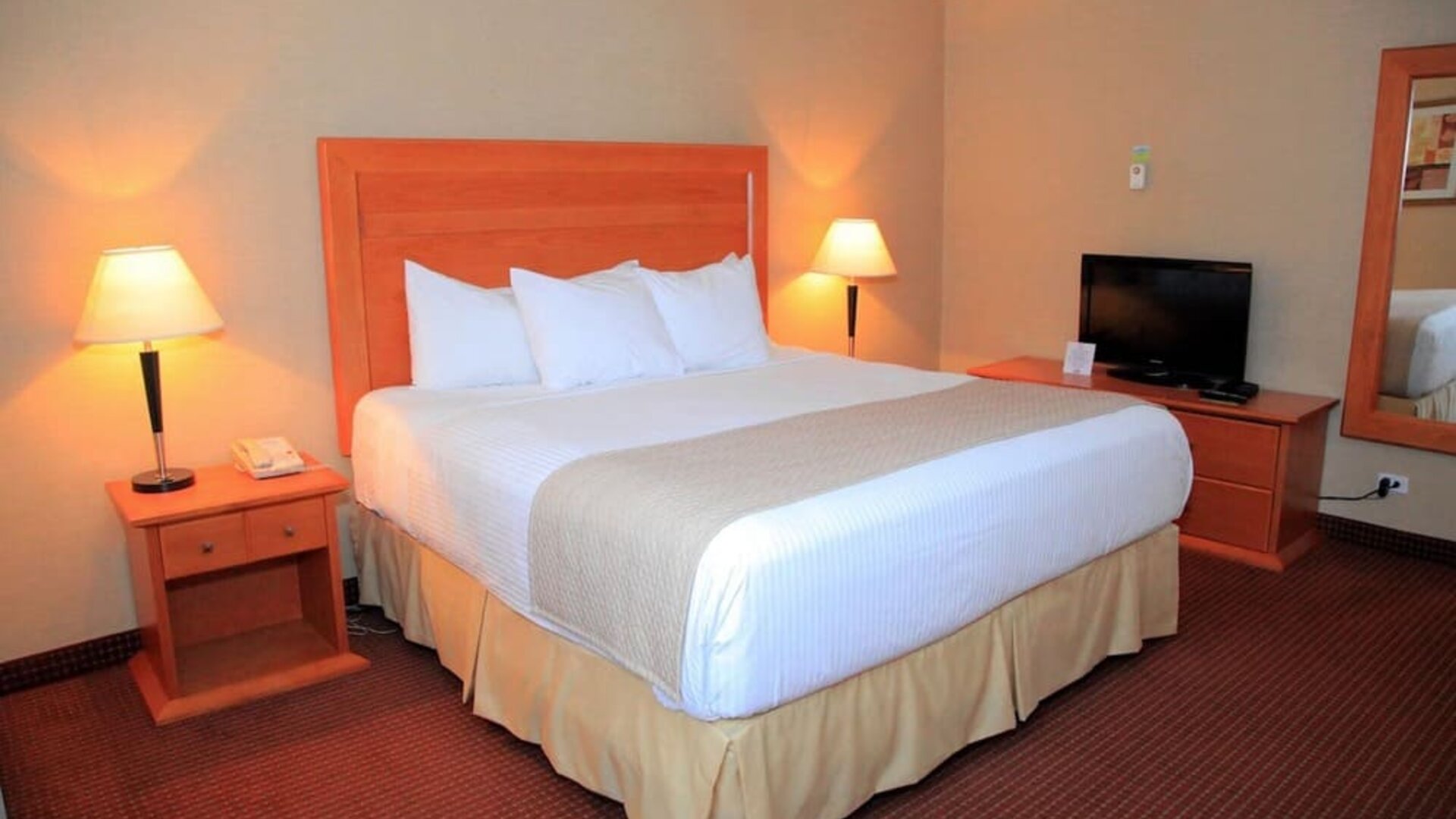 Guest room with a king bed, TV, and bedside tables at Days Inn Edmonton Downtown.