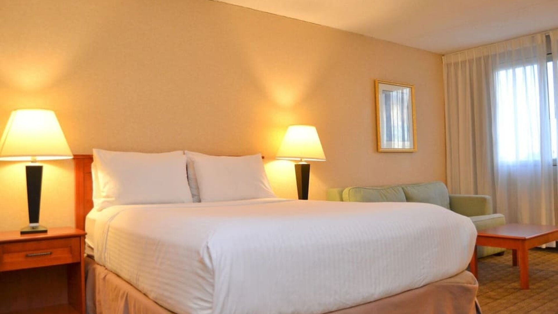 Spacious guest room with a king bed, sofa, and seating area at Amenida Residences.