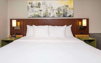 King bed with upholstered headboard and bedside lighting at Comfort Inn Brossard.