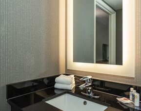 Guest bathroom vanity with an illuminated mirror at Comfort Inn Brossard.