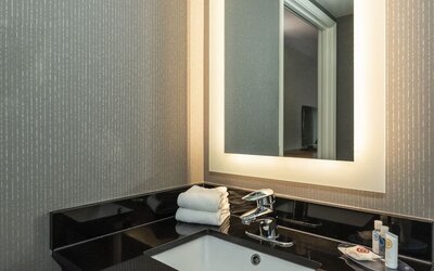 Guest bathroom vanity with an illuminated mirror at Comfort Inn Brossard.