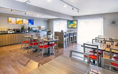 Breakfast dining area with seating and buffet station at Comfort Inn Brossard.