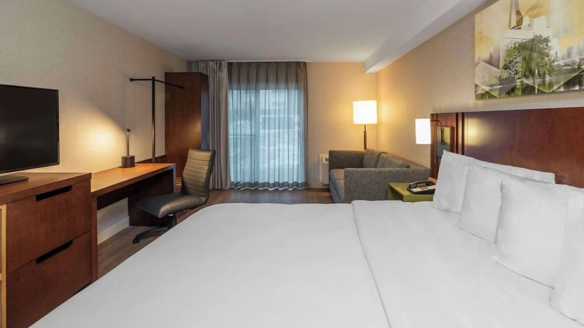 King guest room with a sofa and work desk at Comfort Inn Brossard.