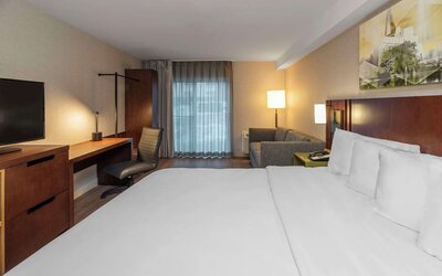 King guest room with a sofa and work desk at Comfort Inn Brossard.