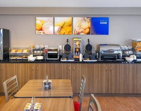 Complimentary breakfast station with waffles, cereals, and hot beverages at Comfort Inn Val D'Or.