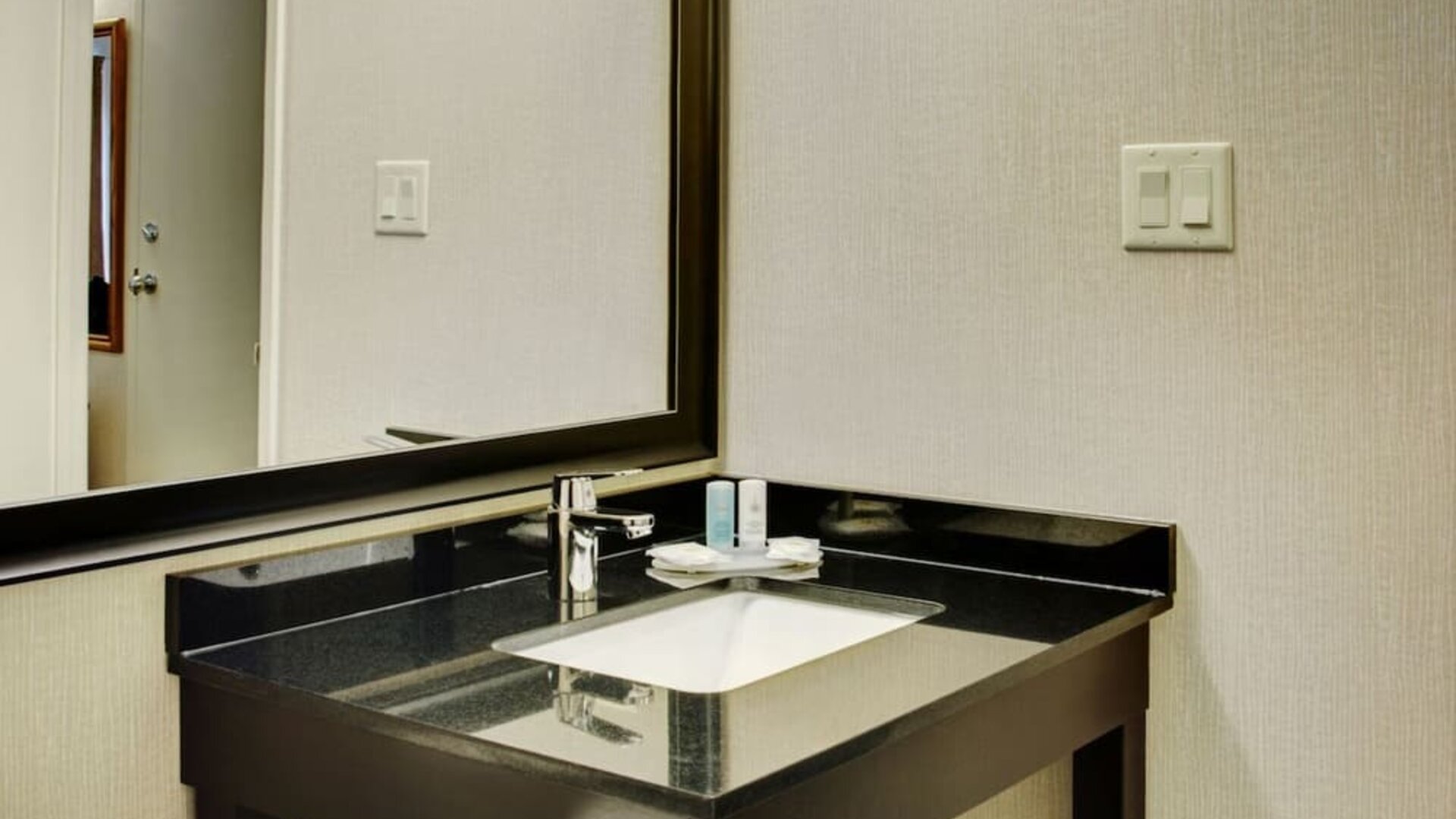 Guest bathroom vanity with a sink and illuminated mirror at Comfort Inn Val D'Or.