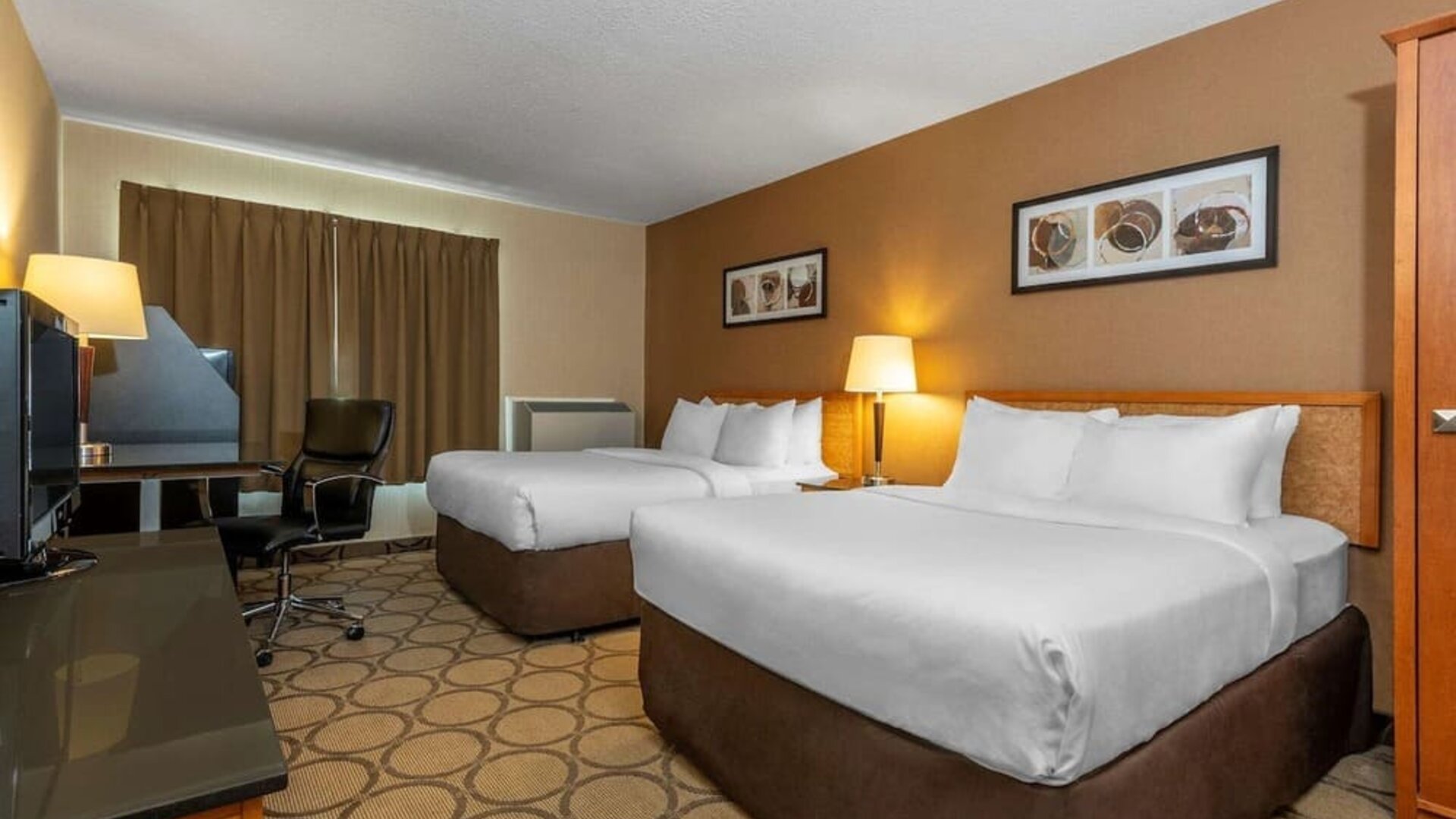 Guest room with two queen beds and a work desk at Comfort Inn Val D'Or.