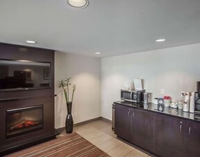 Guest lounge with a fireplace, coffee station, and seating at Comfort Inn Edmonton West.