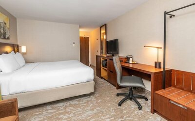 Guest room with a king bed, work desk, and luggage rack at Comfort Inn Ottawa East.