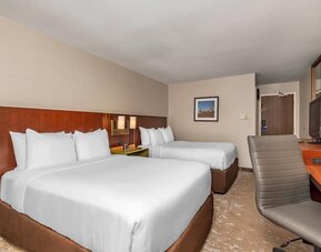 Guest room with two queen beds, flat-screen TV, and work desk at Comfort Inn Ottawa East.