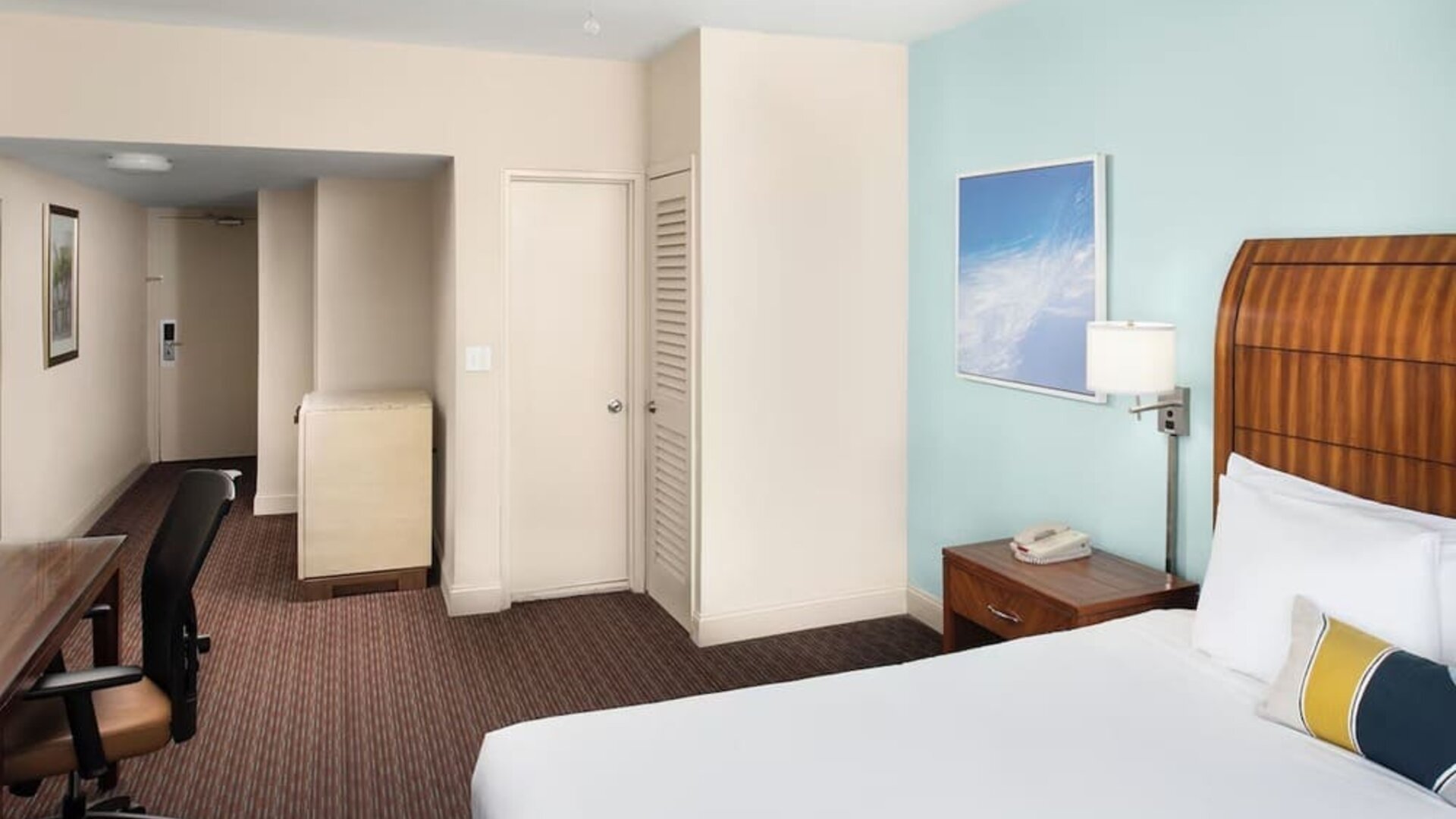 Guest room with a king bed and work desk at Sherry Frontenac Oceanfront Hotel.