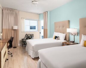 Guest room with two queen beds and work desk at Sherry Frontenac Oceanfront Hotel.