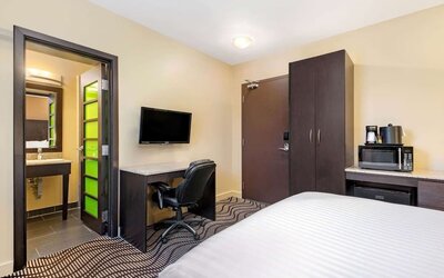Guest room with a workspace, microwave, and mini fridge at La Quinta Inn & Suites By Wyndham Oshawa.