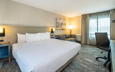 Spacious guest room with a king bed and seating area at Comfort Inn Saskatoon.