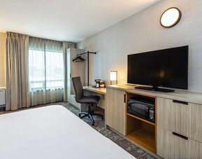 Guest room workspace with a desk, TV, and microwave at Comfort Inn Saskatoon.