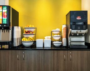 Breakfast station with coffee, juice, and fresh fruit at Comfort Inn Saskatoon.