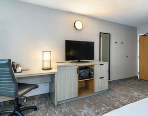 In-room workspace with a desk, TV, and microwave at Comfort Inn Saskatoon.