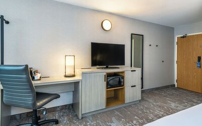 In-room workspace with a desk, TV, and microwave at Comfort Inn Saskatoon.