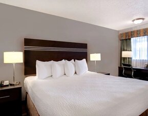 Guest room with a king bed and work desk at Days Inn Vernon.