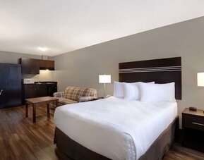 Guest room with a king bed, sofa, and kitchenette at Days Inn Vernon.