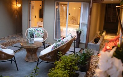 Private courtyard with cushioned outdoor seating surrounded by guest room entrances and plants at Marbore Hotel & Spa.