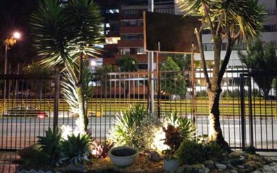 Landscaped garden with tropical plants and illuminated pathways beside the hotel at night at Marbore Hotel & Spa.