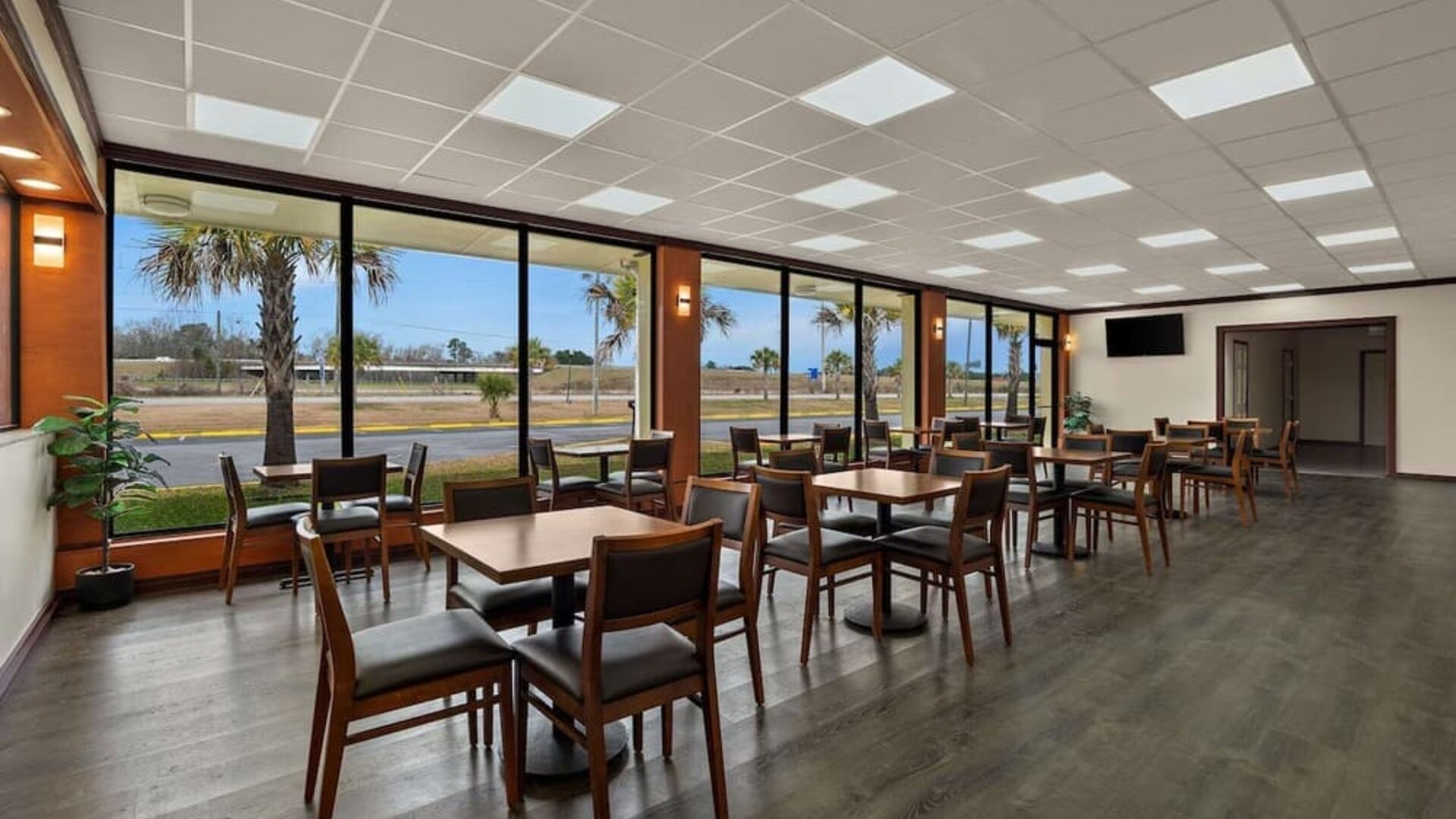Bright breakfast dining area with wooden tables, large windows and views of the hotel grounds at Quality Inn Yemassee - Point South I-95.