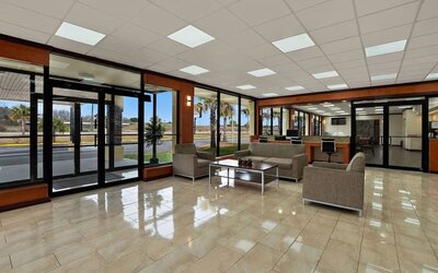 Lobby lounge with cushioned seating, business center workstations and floor-to-ceiling windows at Quality Inn Yemassee - Point South I-95.