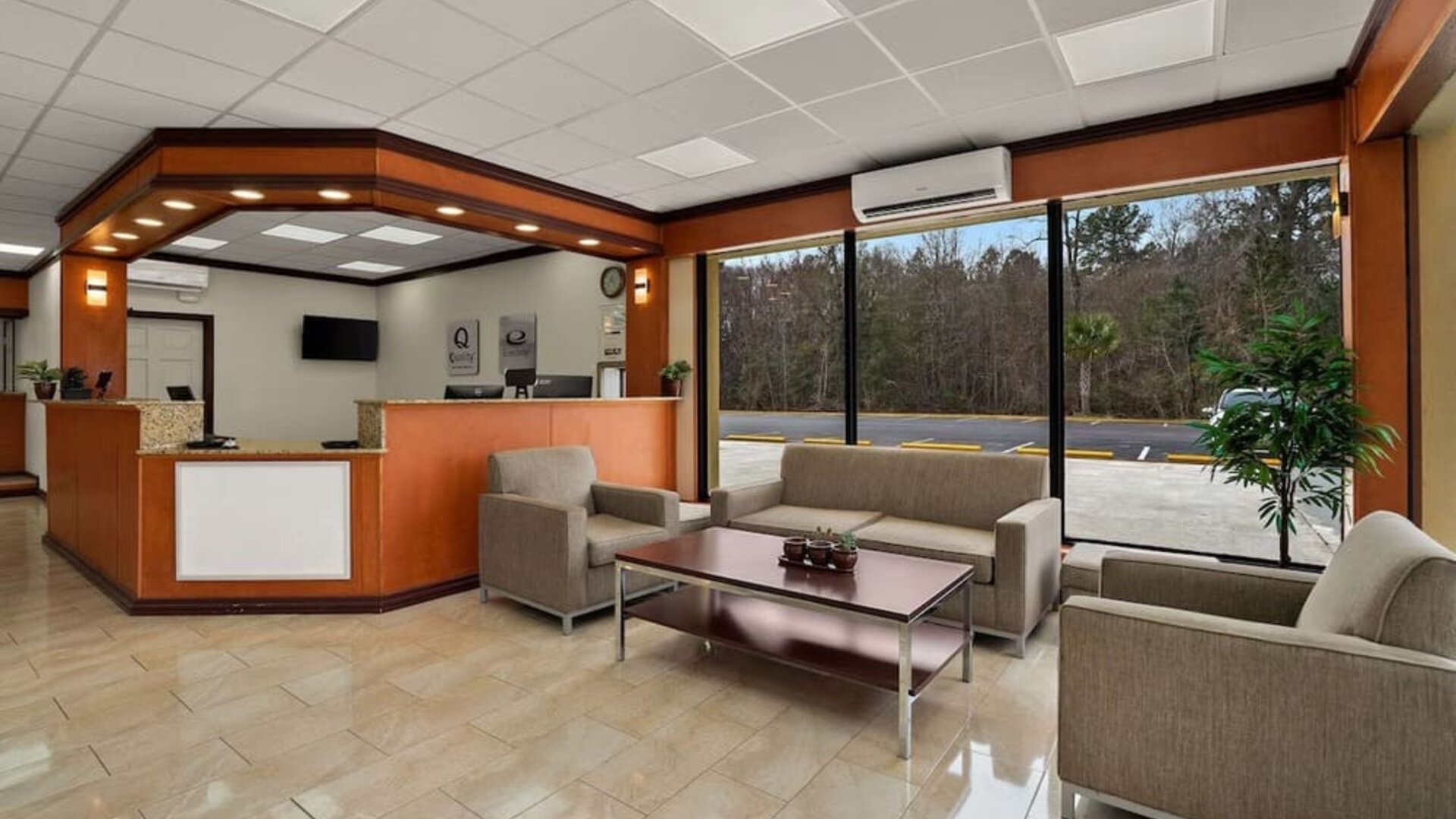 Reception area with front desk, lounge seating and large windows overlooking the parking area at Quality Inn Yemassee - Point South I-95.