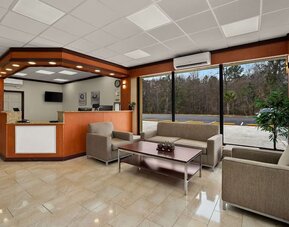 Reception area with front desk, lounge seating and large windows overlooking the parking area at Quality Inn Yemassee - Point South I-95.